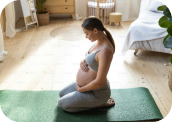 mujer embarazada practicando yoga sentada en el piso en el interior de una casa en la pose del diamante