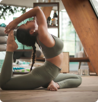 mujer vestida de verde realizando yoga dentro de un studio